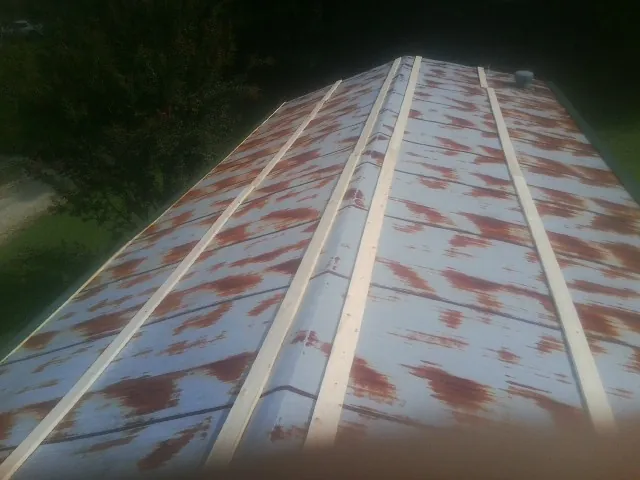 Rusted metal roof panels with new wood purlins before replacement — Storm Damage Roof Repair in Winterset by Roofing Brothers