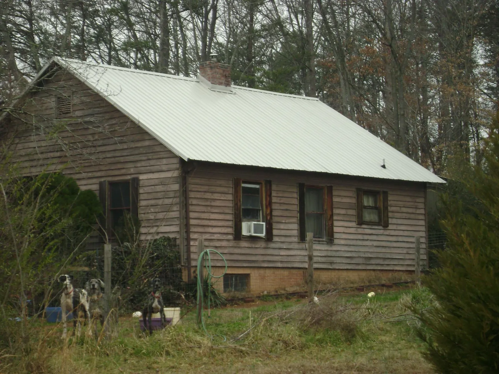 White metal roof on an old wood sided farmhouse, from a Asphalt Shingle Roof Repair job in Winterset